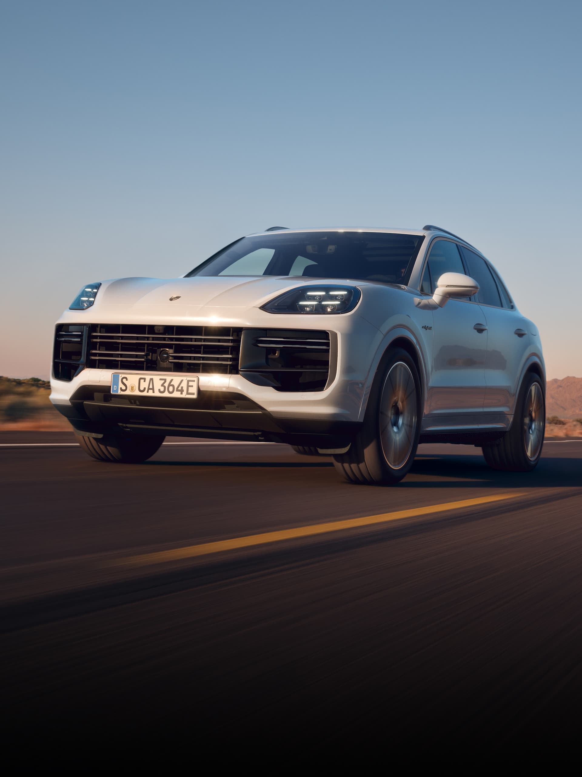 Ein Porsche Cayenne fährt auf offener Straße.